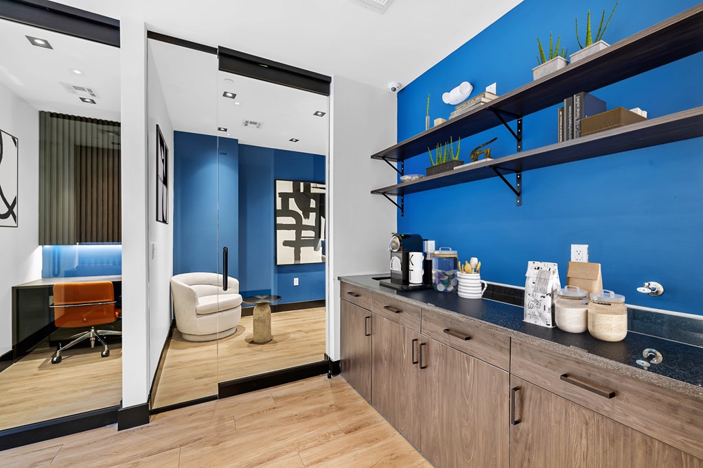A blue wall with shelves and a chair.
