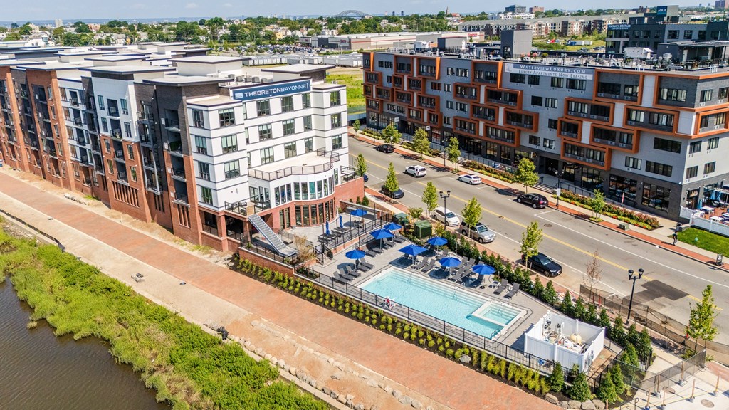 A view of a river and apartment buildings with a pool in the foreground.
