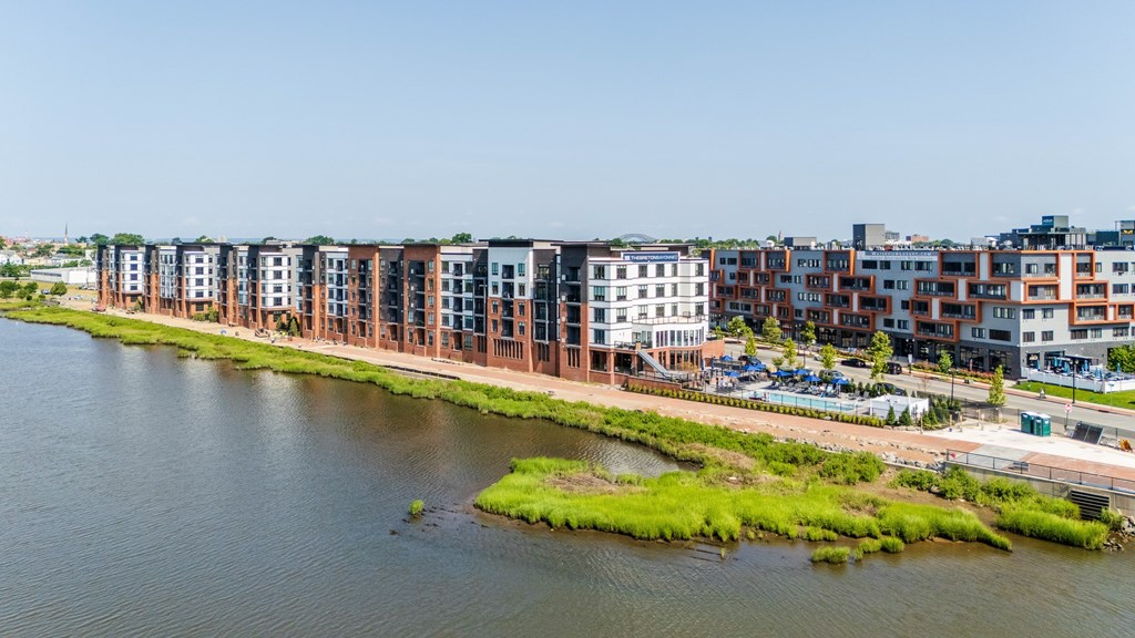 A row of modern buildings are situated along the water's edge.