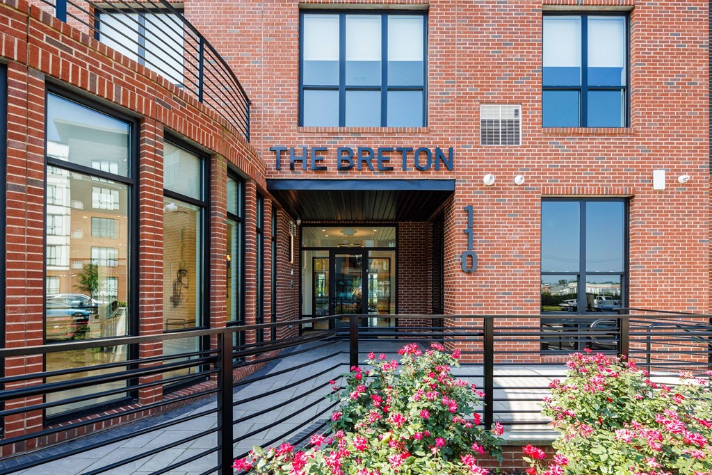 The Breton building has a black railing in front of it.