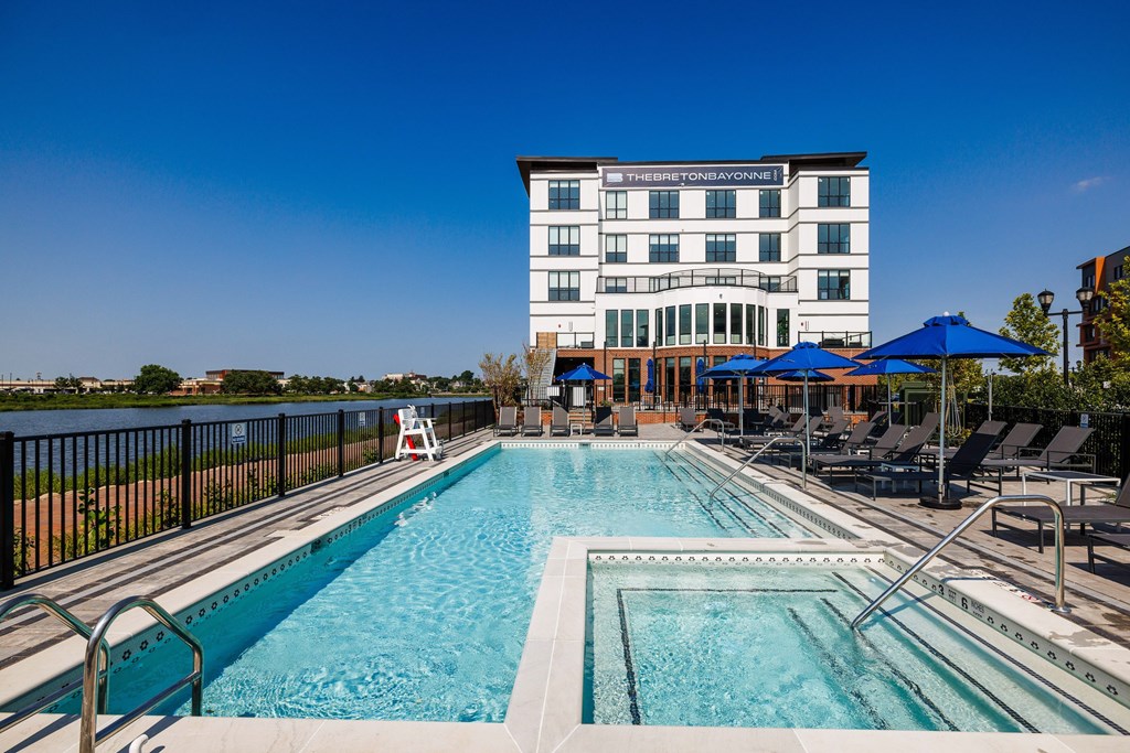 A large swimming pool with a building in the background.