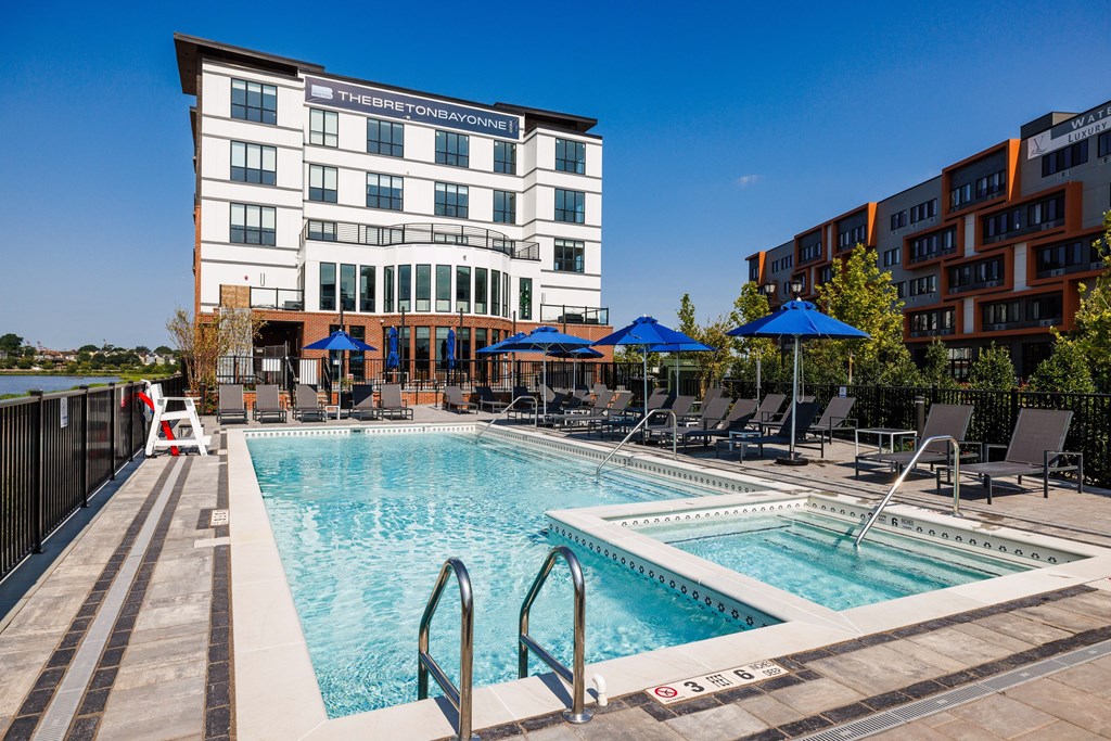 A large swimming pool in front of a hotel.