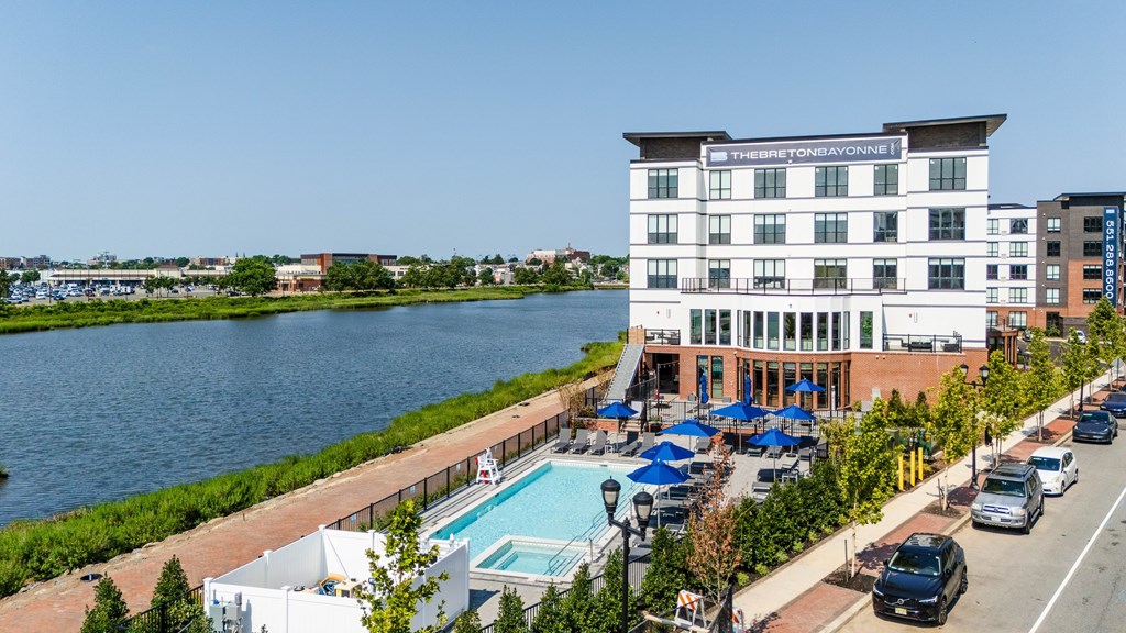A hotel with a pool and a view of the water.