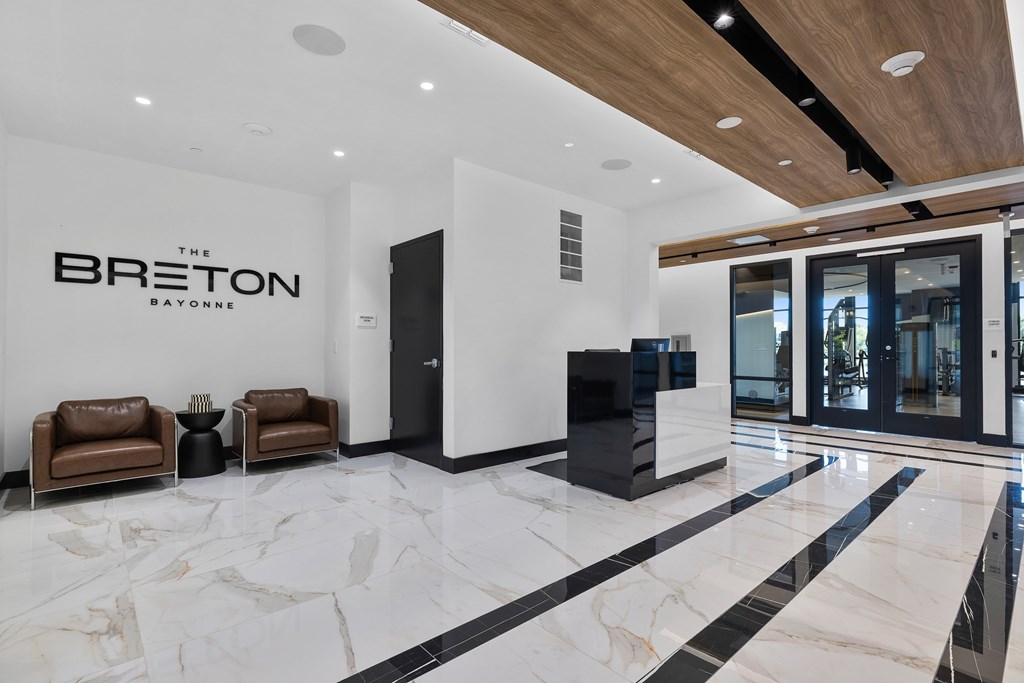 A lobby with a marble floor and a reception desk.