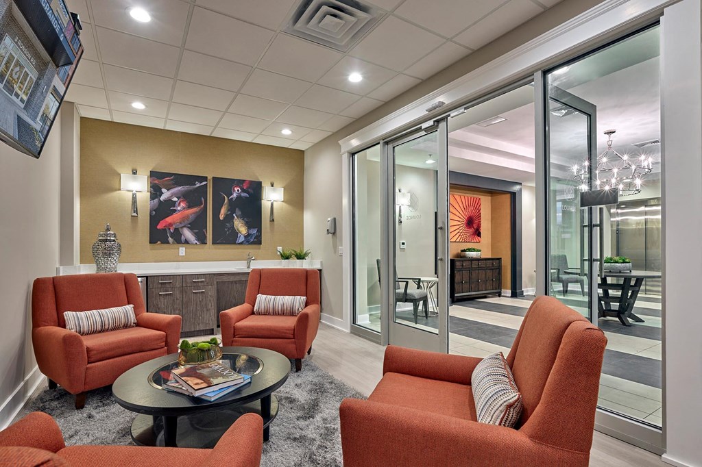 a living room with orange chairs and a table