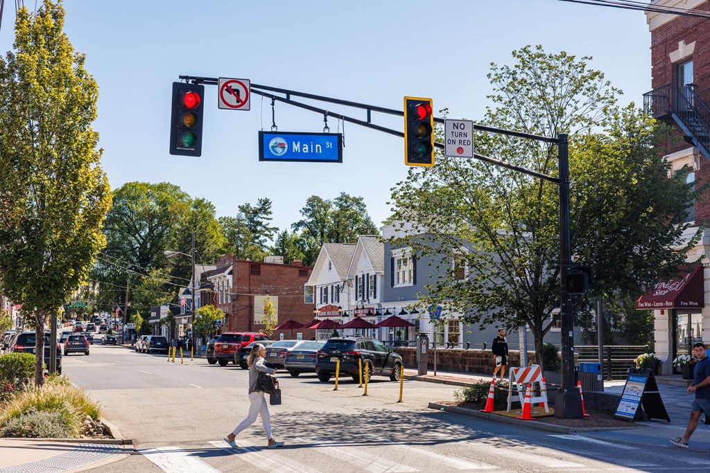 A woman is crossing the street at a crosswalk.
