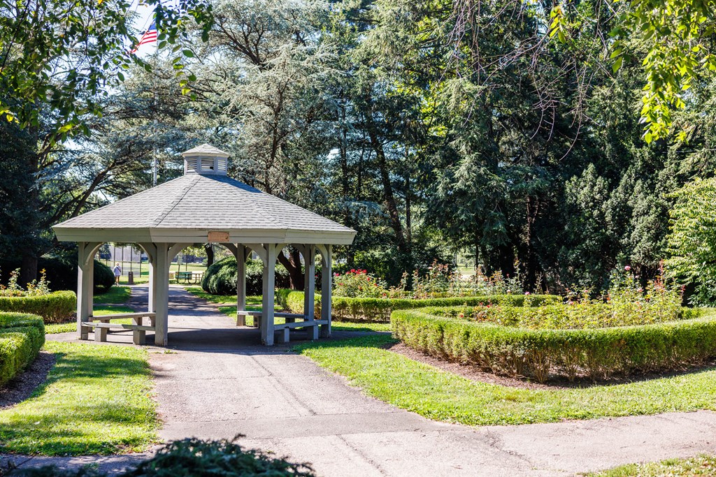 A gazebo is surrounded by trees and bushes.