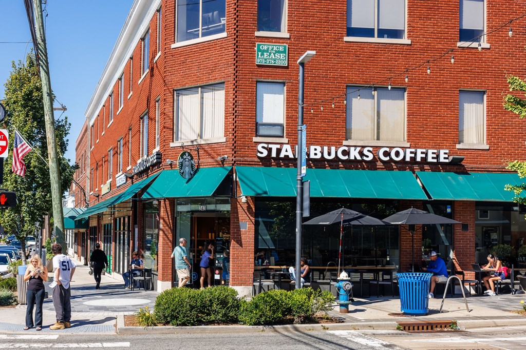A Starbucks Coffee shop with people sitting outside.