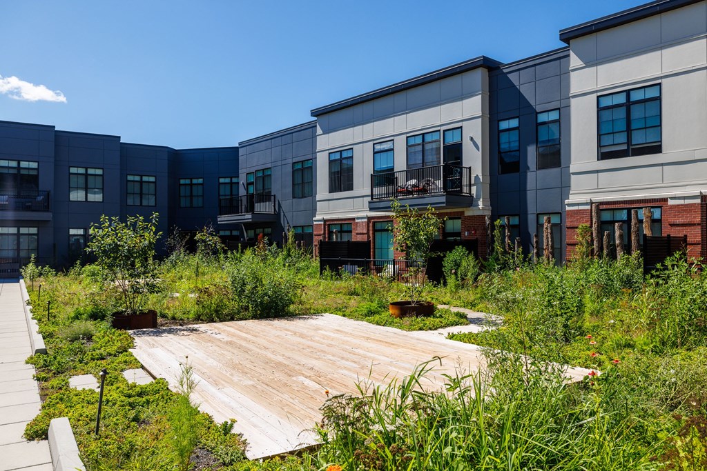 A modern building complex with a wooden deck in the foreground.
