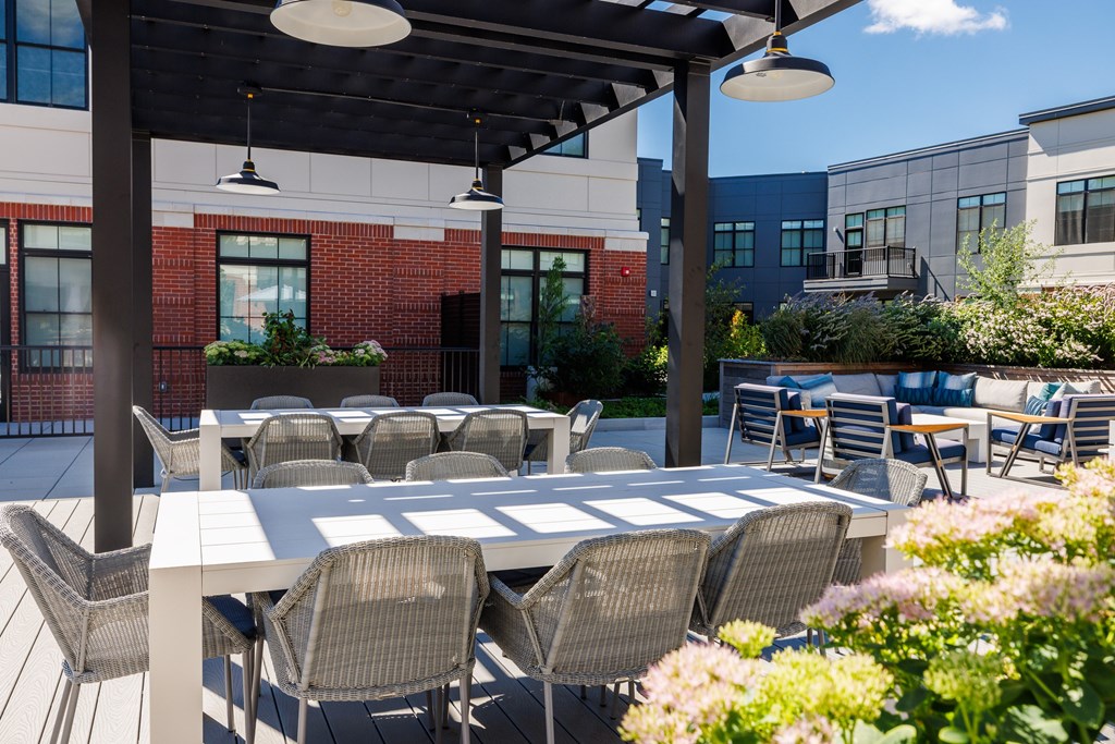 A patio with a table and chairs is covered by a roof.