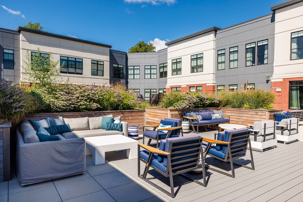 A patio with blue chairs and a white couch.