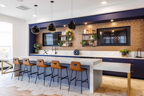 a large kitchen with a long white counter and chairs