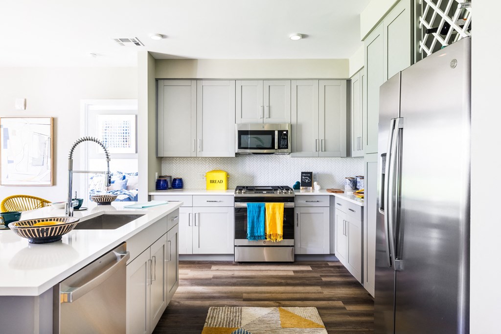 a kitchen with white cabinets and stainless steel appliances