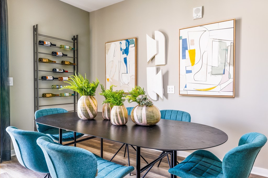a dining room with blue chairs and a table with vases on it