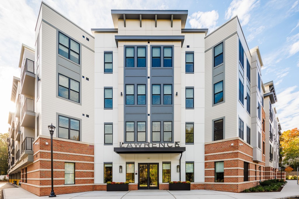 A modern multi-story building with a white and grey facade and a black awning.