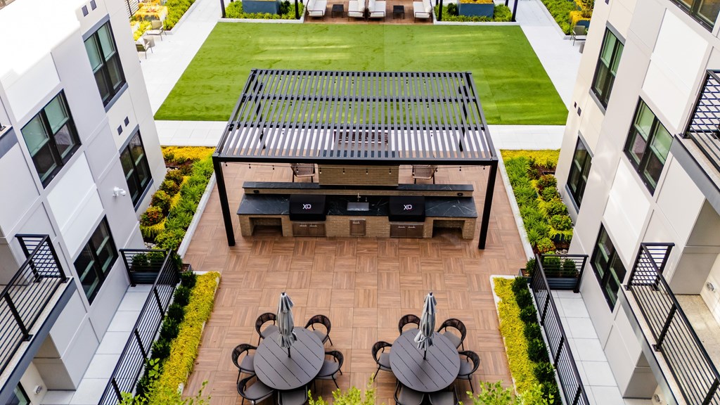 A patio with a table and chairs is surrounded by white buildings.