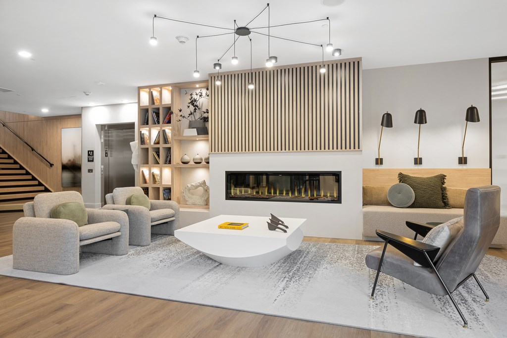 A modern living room with a fireplace and a grey sofa.