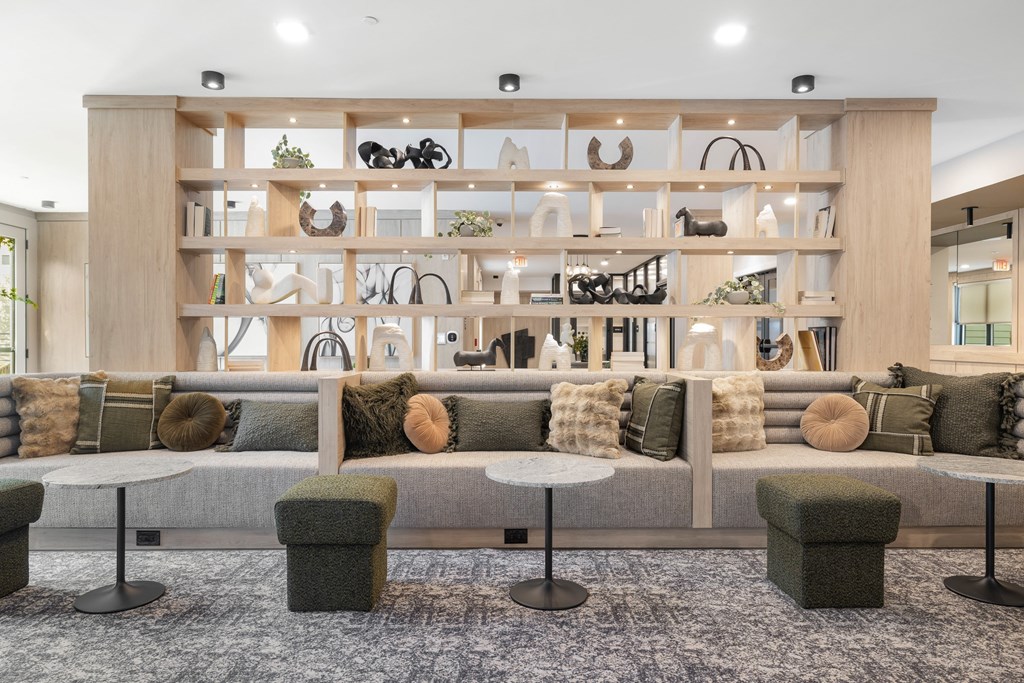 A room with a long couch and a shelf with various items on it.