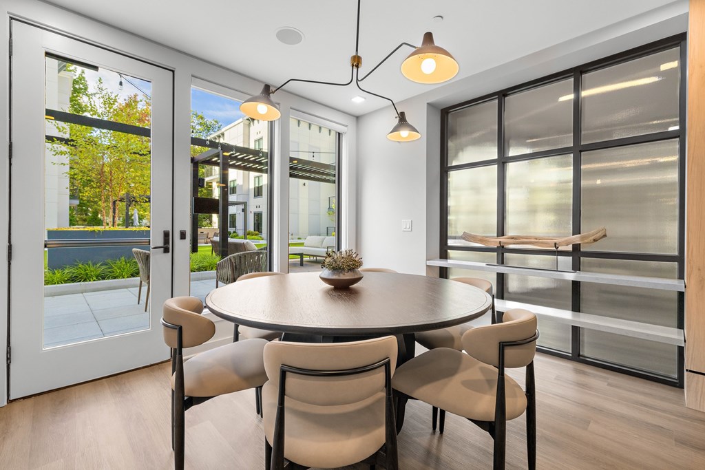 A modern dining room with a round table and chairs.
