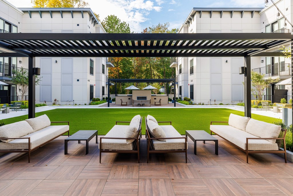 A patio with a table and chairs under a pergola.