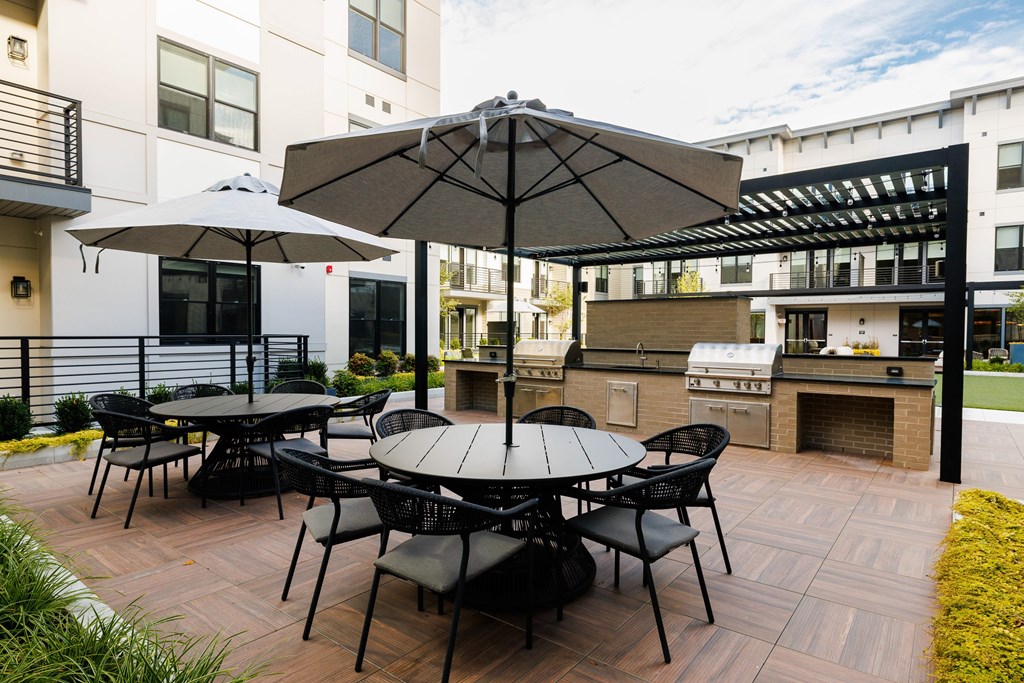 A patio with a table and chairs and an umbrella.