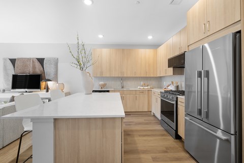 A modern kitchen with wooden cabinets and a white island.