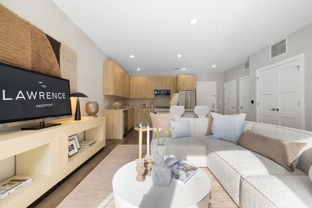 A living room with a white couch and a television on a stand.