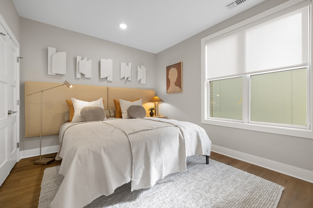 A bedroom with a large bed and a window.