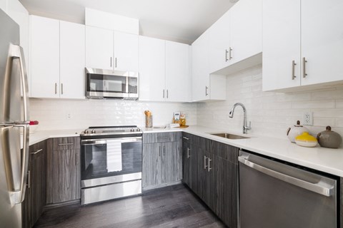 a modern kitchen with white cabinets and stainless steel appliances