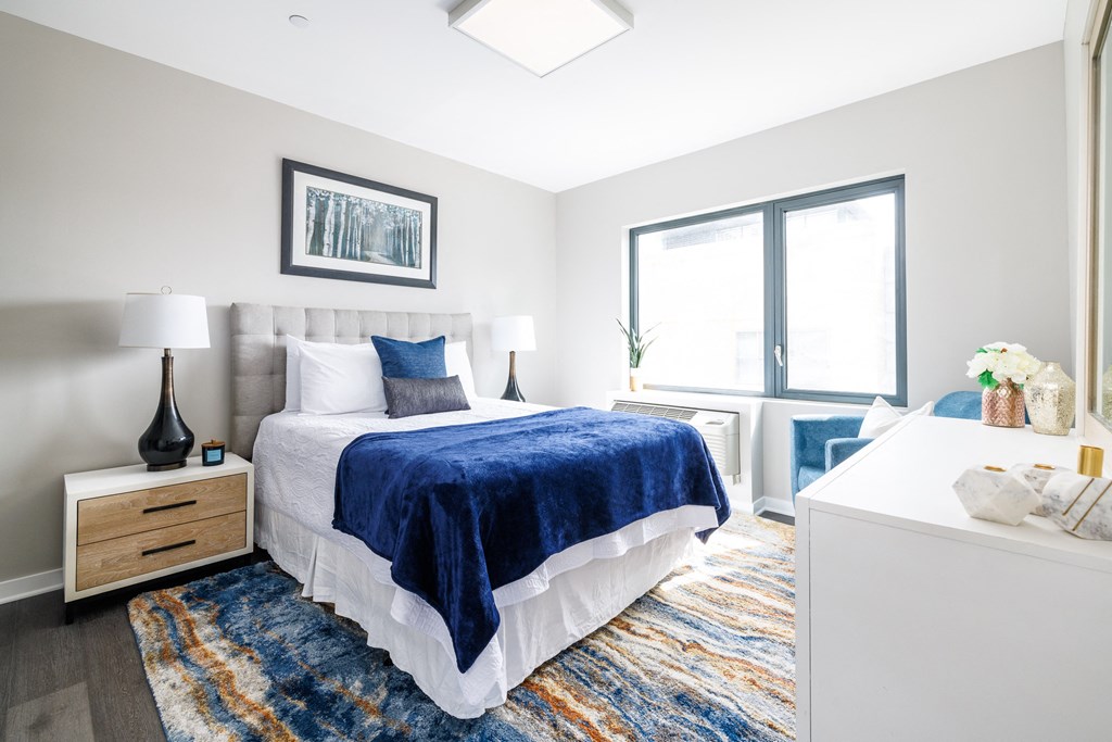 a bedroom with a bed and two windows