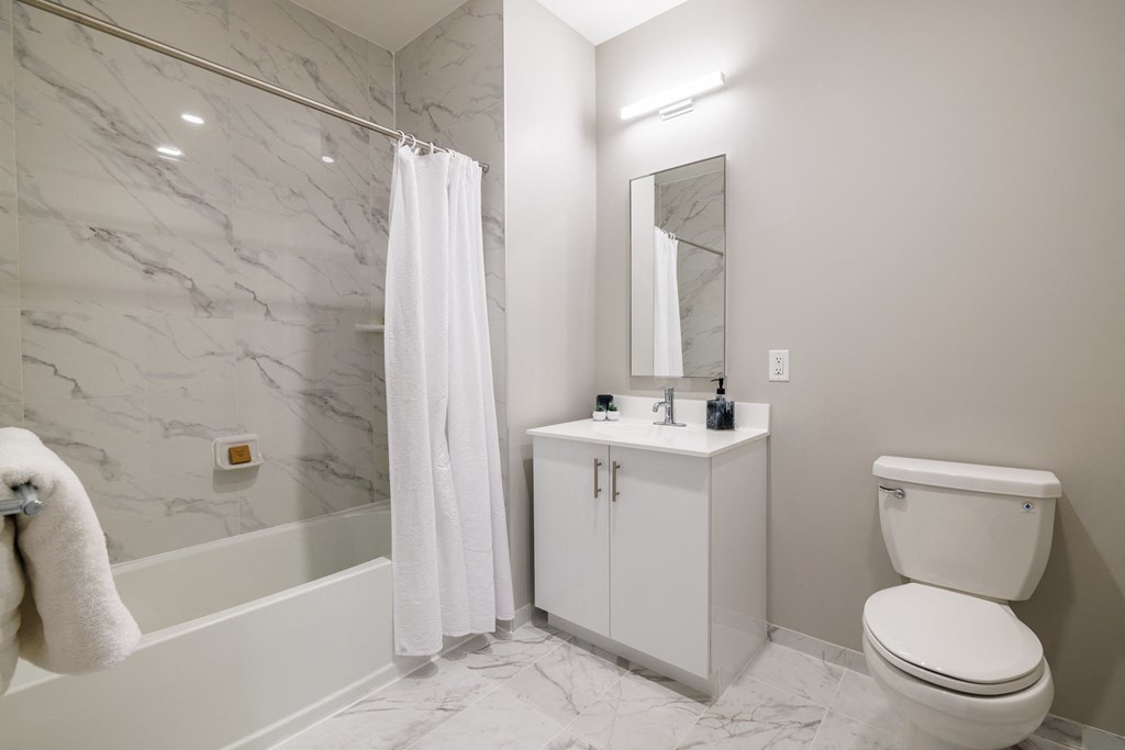 a bathroom with a white sink and toilet next to a bathtub with a shower curtain