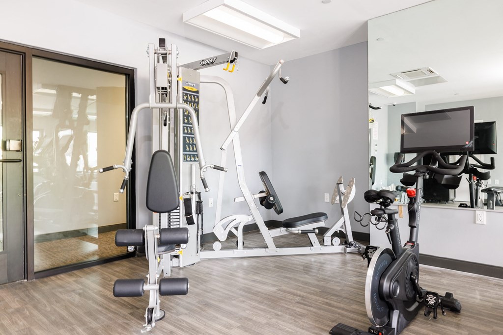 a gym with exercise equipment and a tv