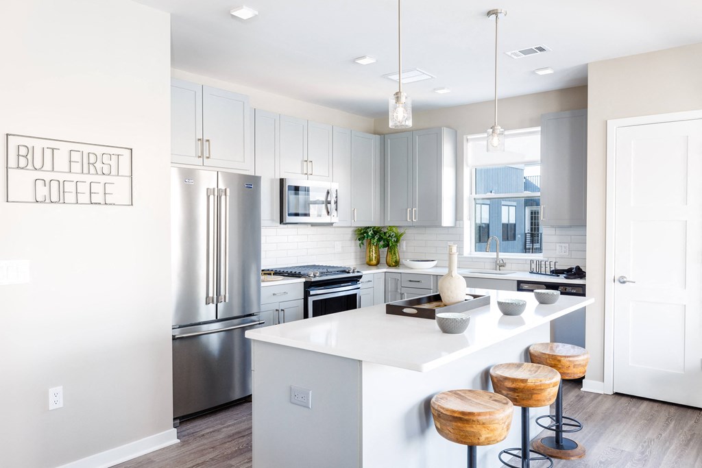 a kitchen with a large island and stainless steel appliances