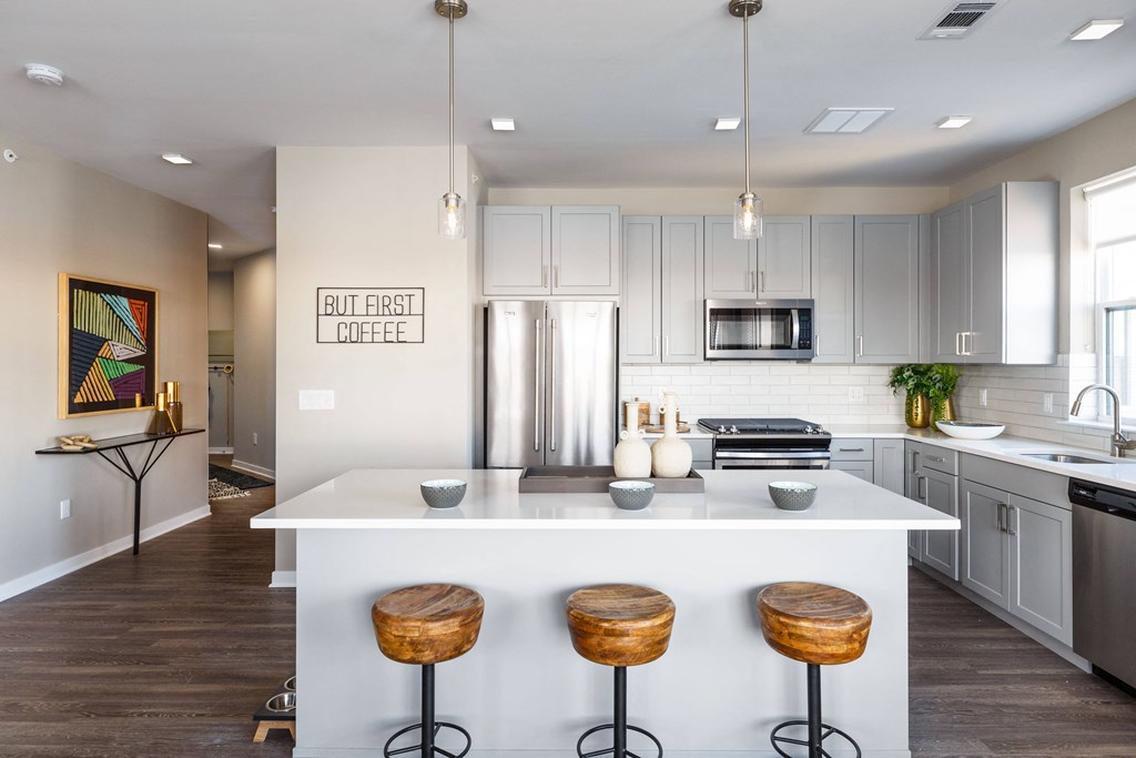a kitchen with a large island with three stools