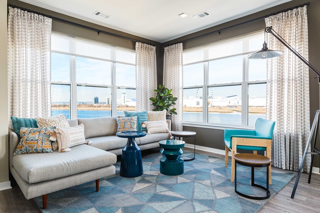 a living room with a view of the water and a couch and chairs