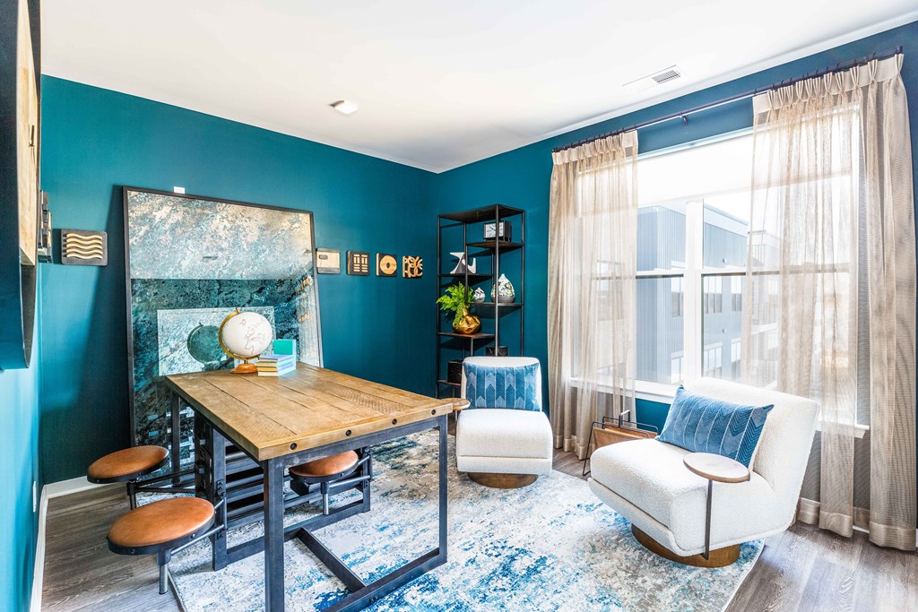 a living room with blue walls and a table and chairs