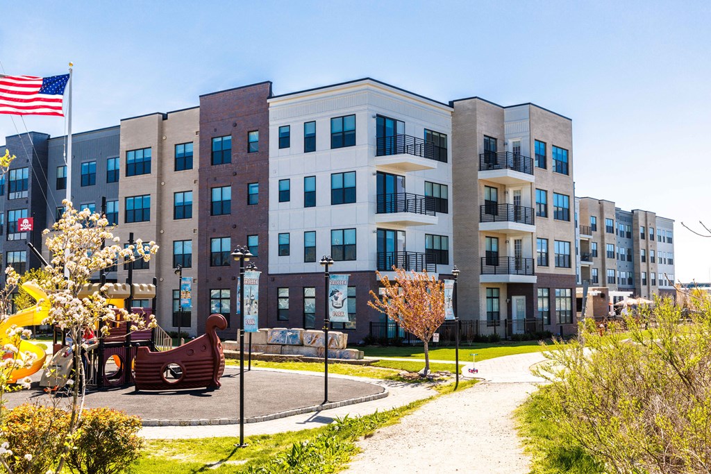 a large apartment building with a playground in front of it