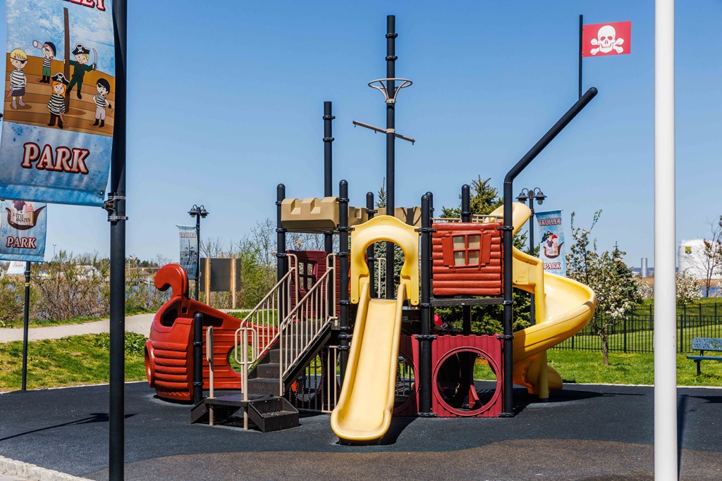 a playground with a yellow slide and a red