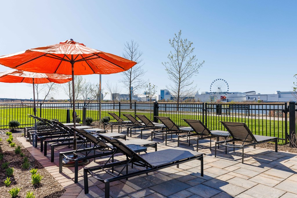 a patio with chairs and umbrellas and a view of the ferris wheel