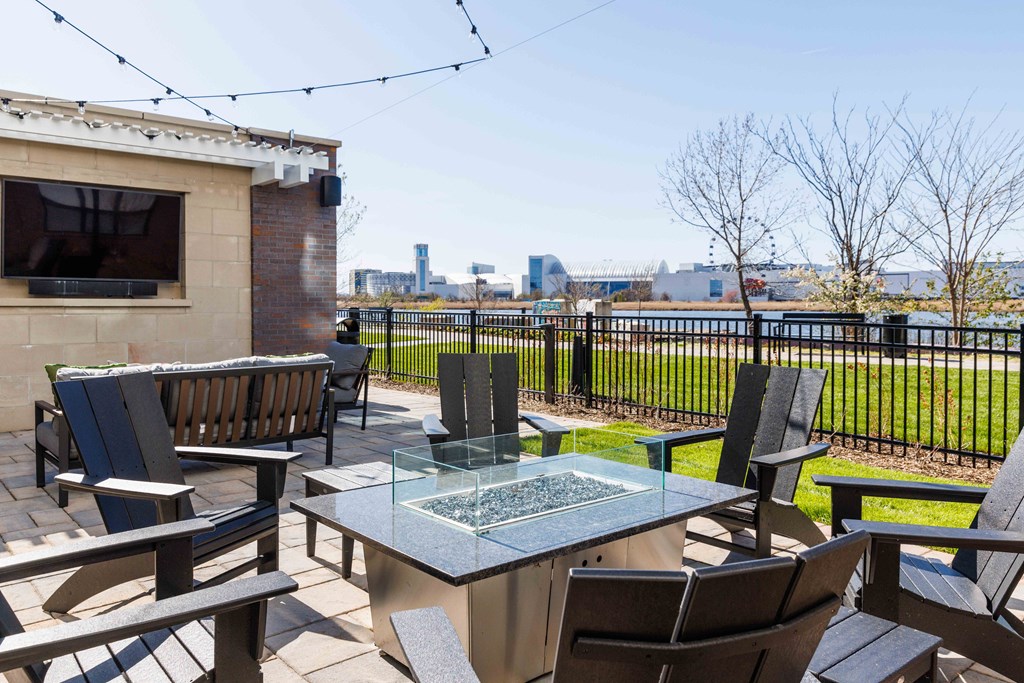 a patio with a glass table and chairs and a view of the city