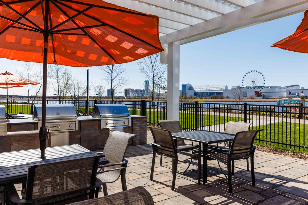 a patio with tables and chairs and an umbrella