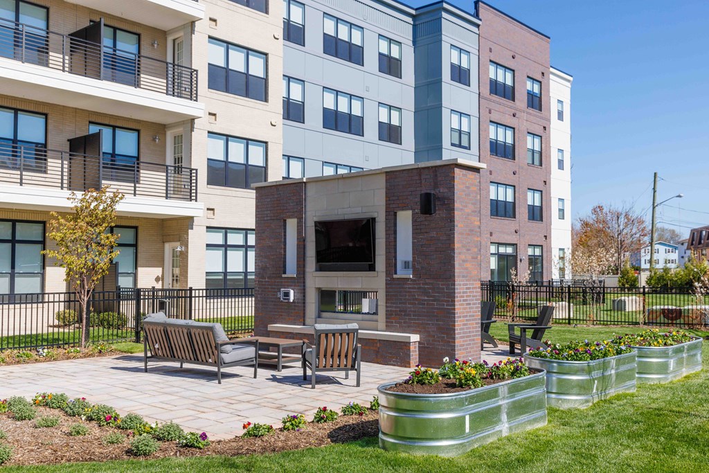 A modern building with a brick fireplace in the courtyard.