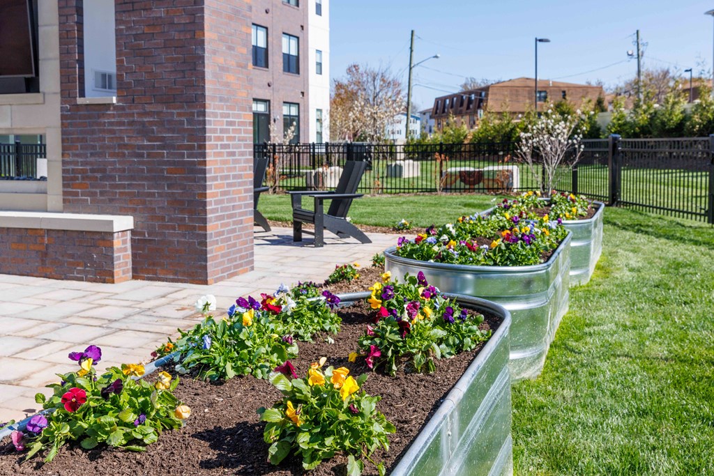A garden with a brick pillar and a bench.