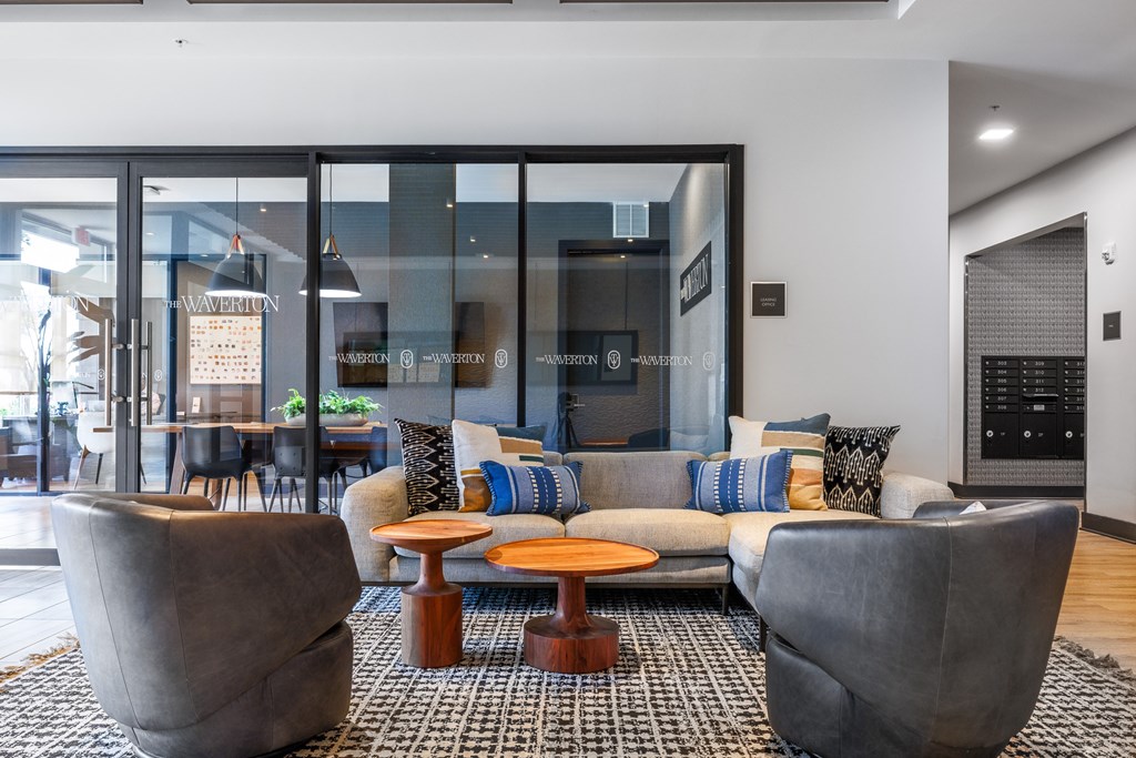 A modern living room with a grey sofa, two armchairs and a coffee table.