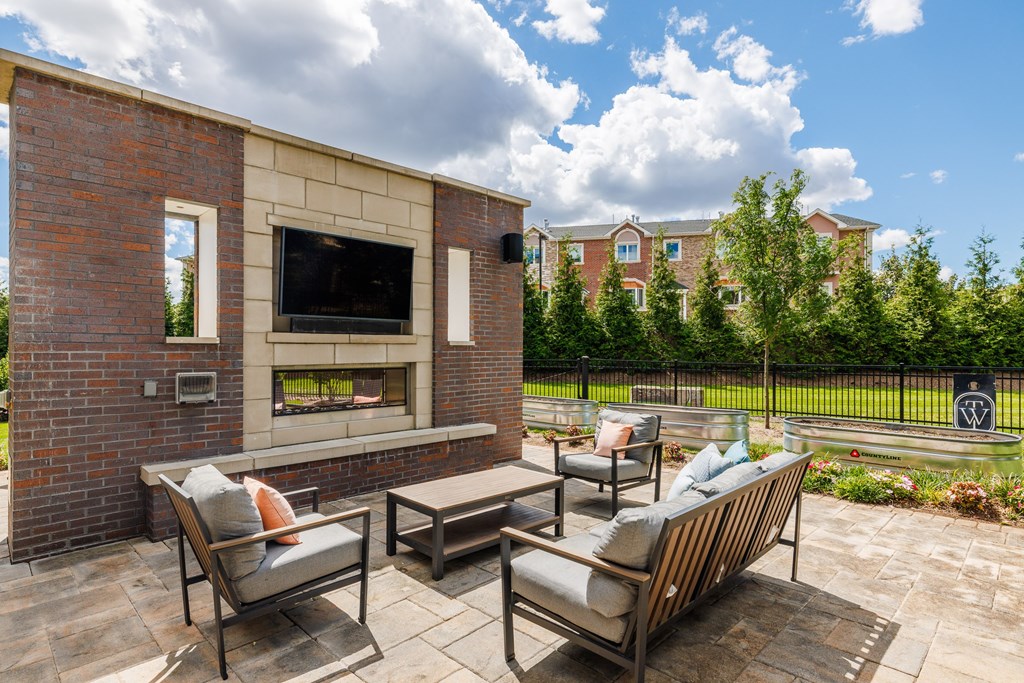 A patio with a brick wall and a television.