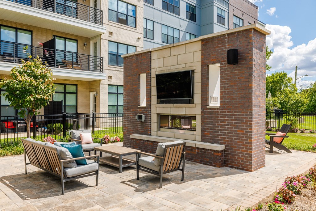 A patio with a brick fireplace and seating area.