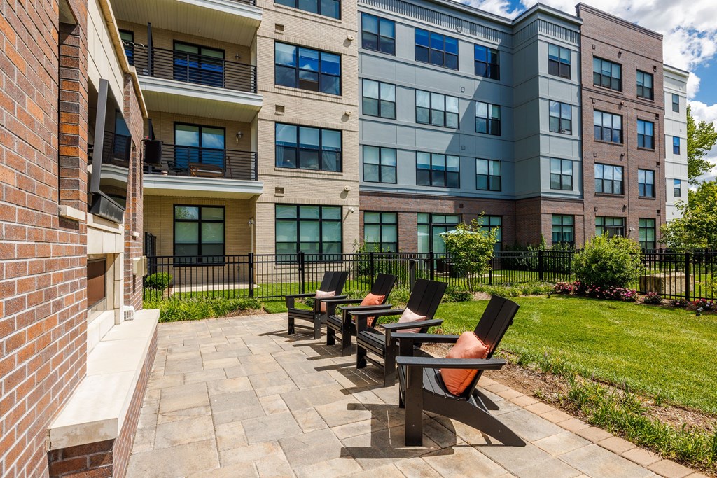 A row of black chairs are lined up on a patio.