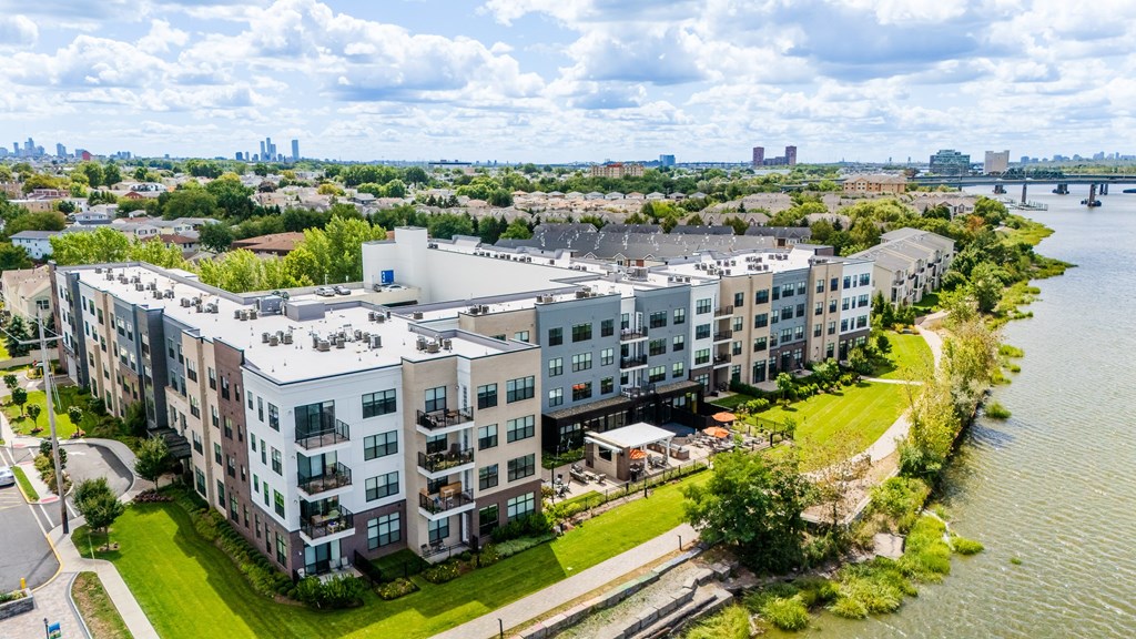 A large apartment complex sits on the edge of a river.