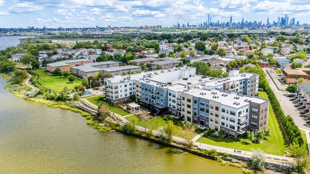 A large body of water is in the foreground of a cityscape.