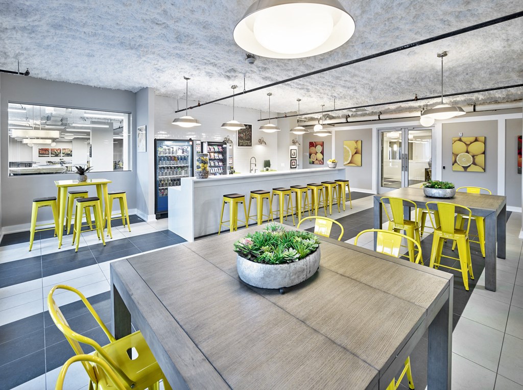 a dining room with yellow chairs and a table with a plant on it